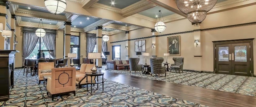 Hotel lobby with patterned carpet, chandeliers and plush furniture