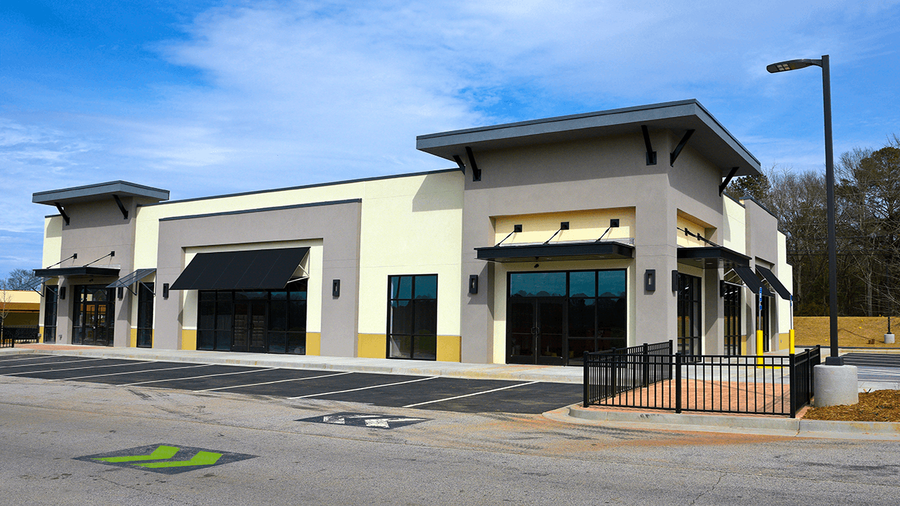 Exterior of a multitenant retail building. Parking spaces in view.